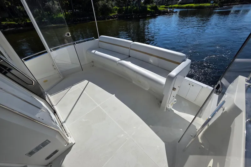 Slide: The Image of 2005 Carver 41 Cockpit Motor Yacht with spacious seating area by the water. - 20
