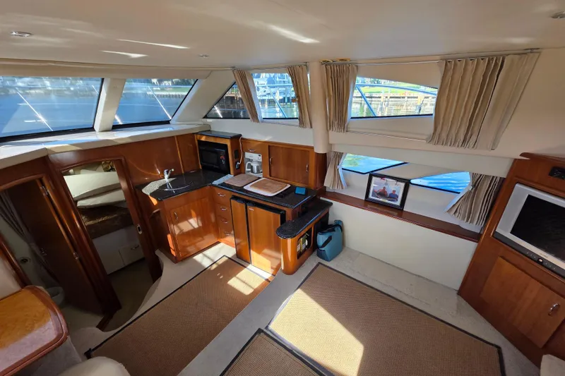 Slide: The Image of Interior of 2005 Carver 41 Cockpit Motor Yacht with kitchen and large windows. - 22