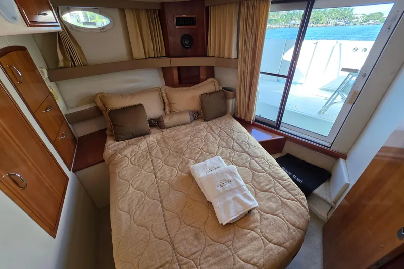 Slide: The Image of Cozy bedroom in 2005 Carver 41 Cockpit Motor Yacht with window view and elegant decor. - 27