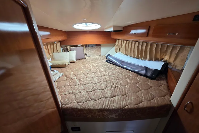 Slide: The Image of Interior cabin of 2005 Carver 41 Cockpit Motor Yacht with cozy bed and wooden accents. - 30