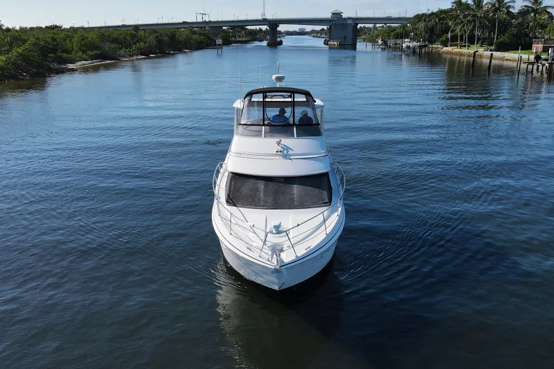 Slide: The Image of 2005 Carver 41 Cockpit Motor Yacht cruising on a serene waterway. - 5