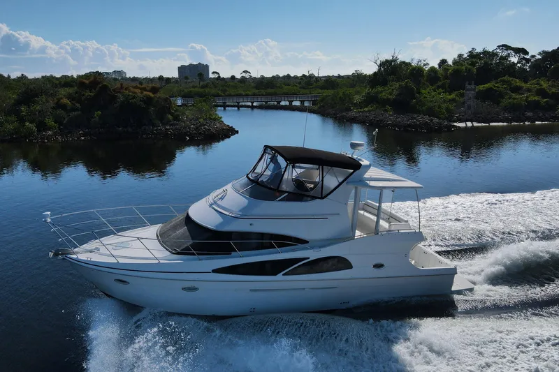 Slide: The Image of 2005 Carver 41 Cockpit Motor Yacht cruising on a serene waterway. - 7