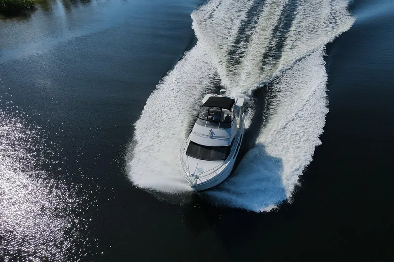 Slide: The Image of 2005 Carver 41 Cockpit Motor Yacht cruising on a sunny day, creating a wake. - 8