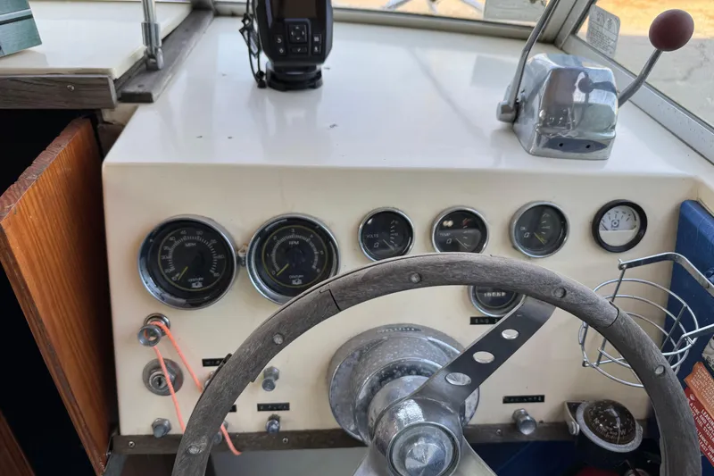 Slide: The Image of 1975 Century Raven boat dashboard with gauges, steering wheel, and throttle controls. - 6