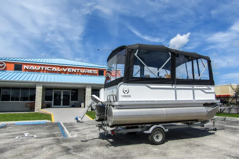Slide: The Image of 2025 Armada v17 pontoon boat on trailer outside Nautical Ventures store. - 2