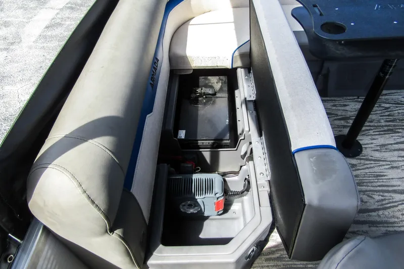 Slide: The Image of Open storage compartment in 2025 Armada v17 boat with visible battery and charger. - 24
