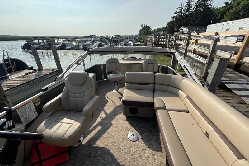 Slide: The Image of 2024 Godfrey SW2286FS pontoon boat with beige seating at a dock. - 6