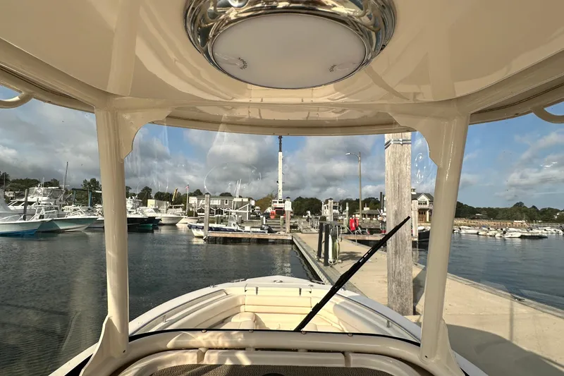 Slide: The Image of 2019 Grady-White Fisherman 257 at marina, clear sky, docked boats in background. - 18