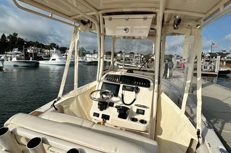 Slide: The Image of 2019 Grady-White Fisherman 257 boat interior at marina, showcasing helm and controls. - 7