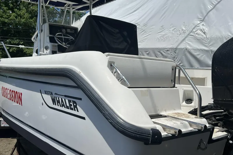Slide: The Image of 2002 Boston Whaler 21 Outrage boat, side view, docked with visible steering console. - 12
