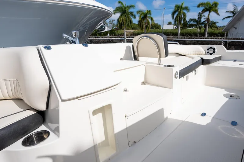 Slide: The Image of 2024 Stingray 212SC boat interior with white seating and cup holders, under a sunny sky. - 7