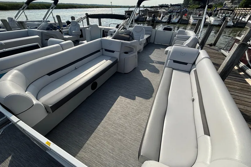 Slide: The Image of 2024 Godfrey Sw2286SB pontoon boat with spacious seating, docked by the water. - 3