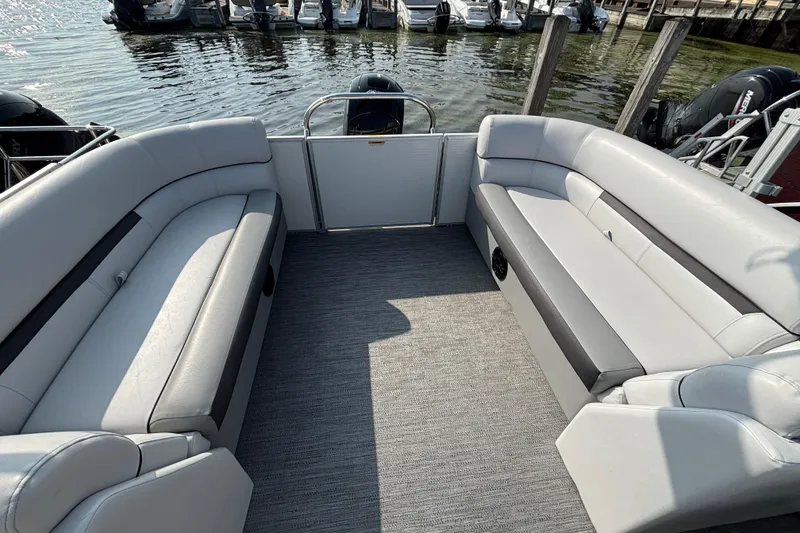 Slide: The Image of 2024 Godfrey Sw2286SB pontoon boat interior with spacious seating and lake view. - 4