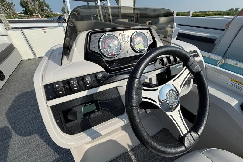 Slide: The Image of 2024 Godfrey Sw2286SB boat dashboard with steering wheel and control panel. - 8