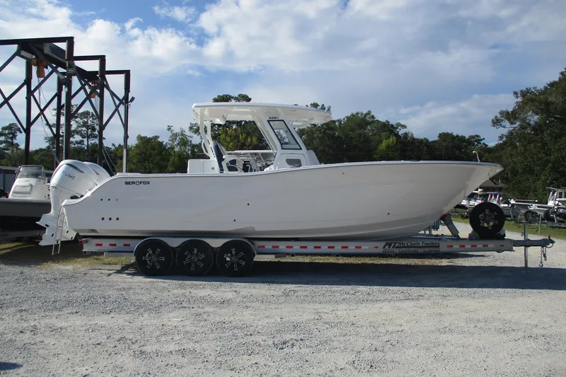 The Image of 2026 Sea Fox 328 Commander boat on trailer, parked outdoors under a cloudy sky. - 0