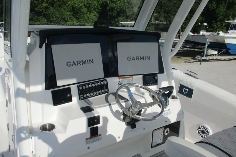 Slide: The Image of 2026 Sea Fox 328 Commander helm with dual Garmin displays and stainless steel steering wheel. - 18