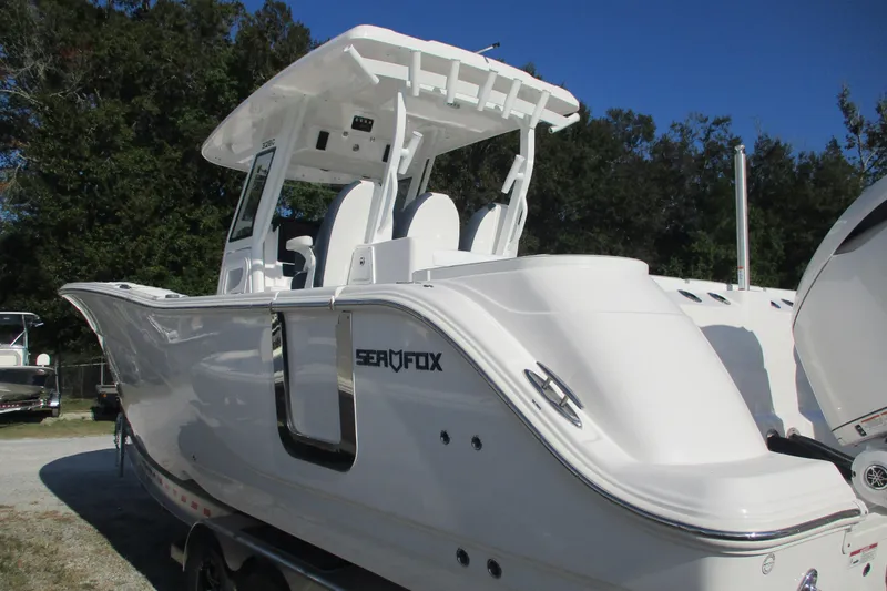 Slide: The Image of 2026 Sea Fox 328 Commander boat, sleek white design, parked outdoors. - 4