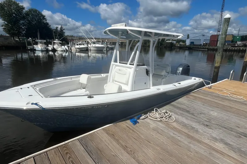 Slide: The Image of 2020 Sea Hunt Triton 210 boat docked at a marina under a partly cloudy sky. - 13
