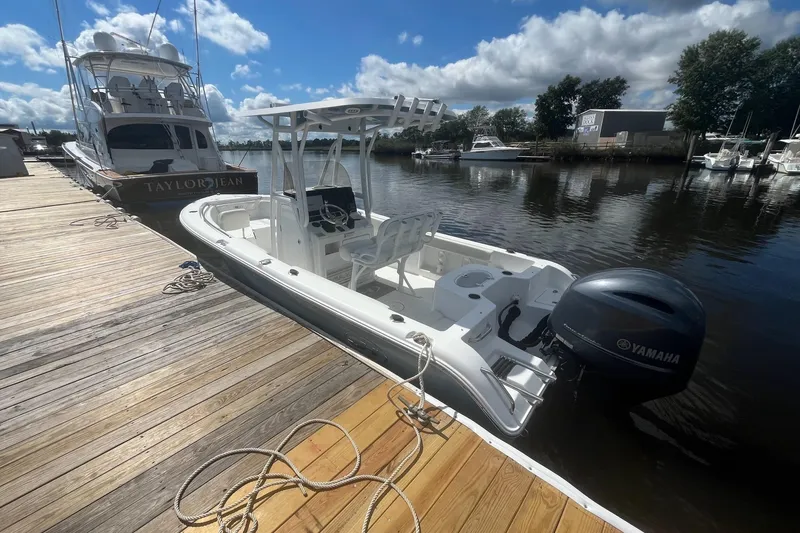Slide: The Image of 2020 Sea Hunt Triton 210 boat docked with Yamaha outboard motor, under a sunny sky. - 14