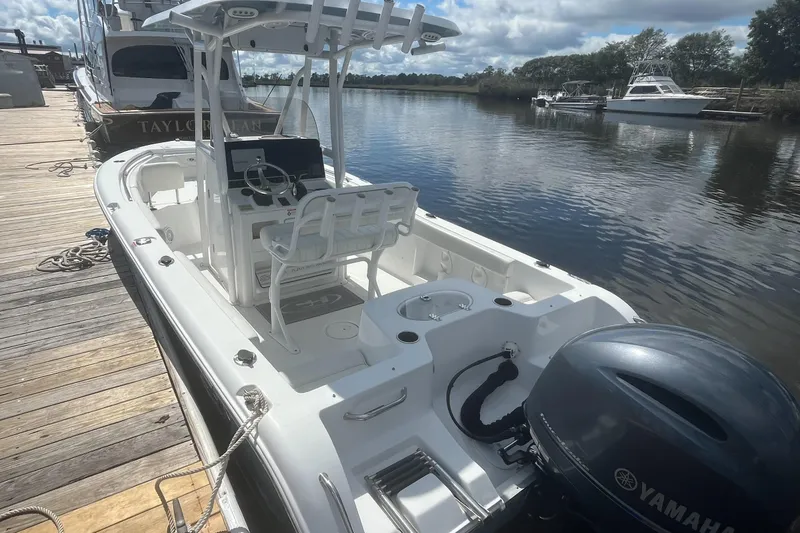 Slide: The Image of 2020 Sea Hunt Triton 210 boat docked, featuring Yamaha outboard motor, clear skies, and calm water. - 8
