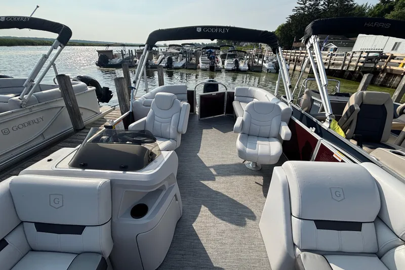Slide: The Image of 2024 Godfrey Sw2286SB pontoon boat interior at a marina dock. - 10
