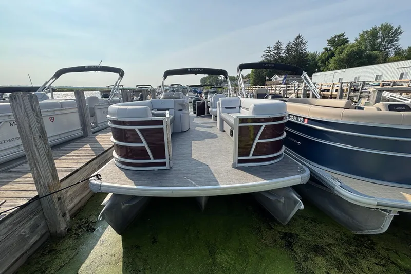 Slide: The Image of 2024 Godfrey Sw2286SB pontoon boat docked at a marina, surrounded by other boats. - 2