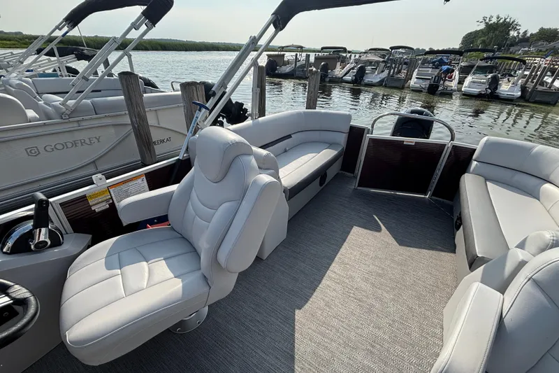 Slide: The Image of 2024 Godfrey Sw2286SB pontoon boat interior with plush seating and modern design. - 4