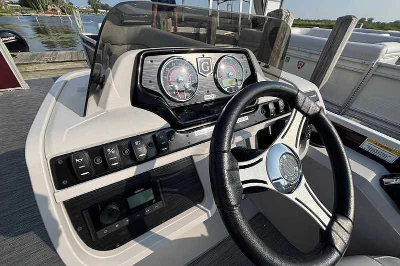 Slide: The Image of 2024 Godfrey Sw2286SB boat dashboard with steering wheel and control panel. - 5