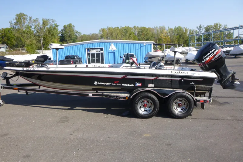 Slide: The Image of 1999 Viper Boats Cobra 201 on trailer, parked near blue building, with Mercury engine. - 3