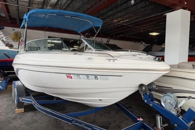 Slide: The Image of Chaparral 196 SSi 2000 boat with blue canopy on trailer in storage facility. - 2
