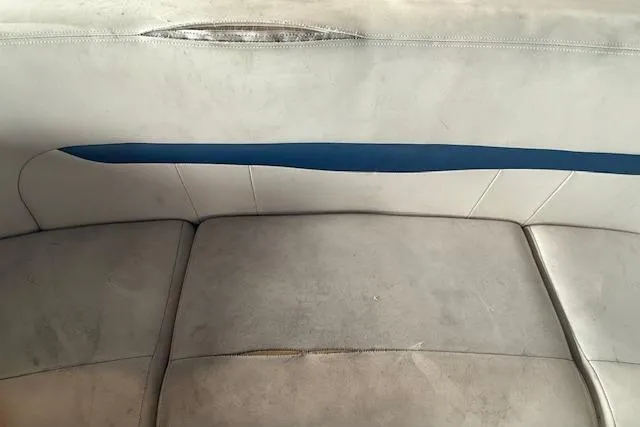 Slide: The Image of Worn interior seating of a 2000 Chaparral 196 SSi boat, featuring blue and white upholstery. - 20