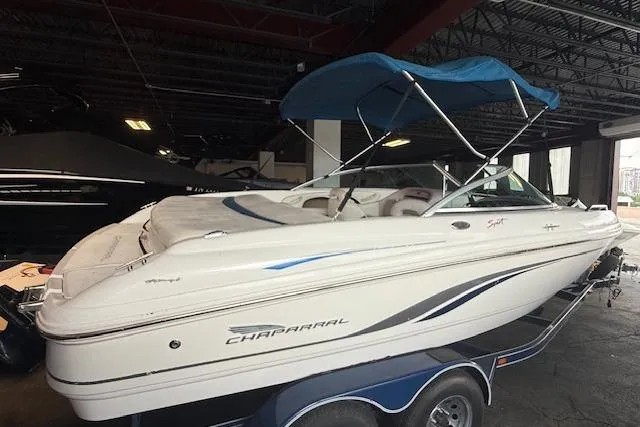 Slide: The Image of 2000 Chaparral 196 SSi boat with blue canopy on trailer in indoor storage. - 3