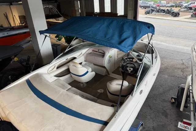 Slide: The Image of 2000 Chaparral 196 SSi boat with blue canopy in a garage setting. - 4