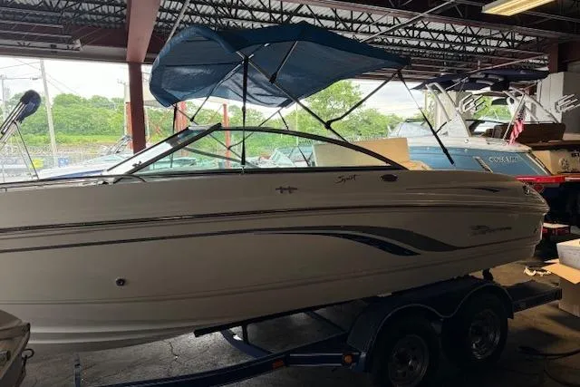 Slide: The Image of 2000 Chaparral 196 SSi boat with blue canopy in a storage facility. - 6