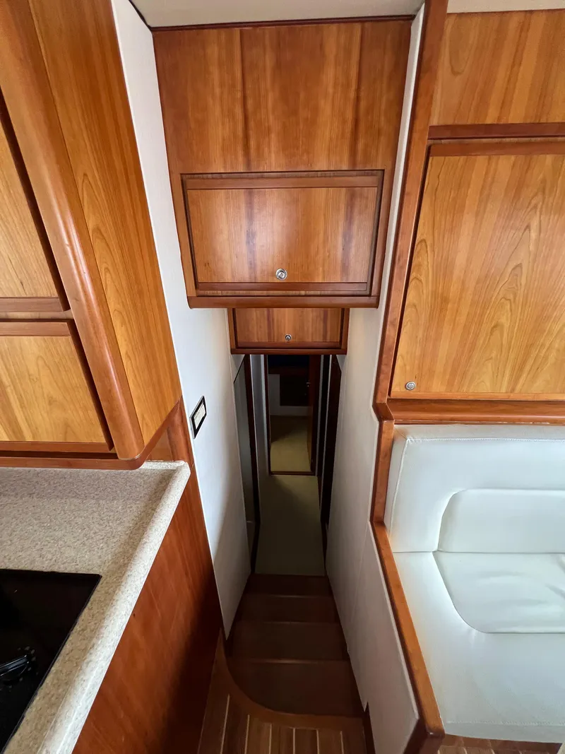 Slide: The Image of 2009 Bertram Convertible yacht interior with wooden cabinetry and narrow hallway. - 15
