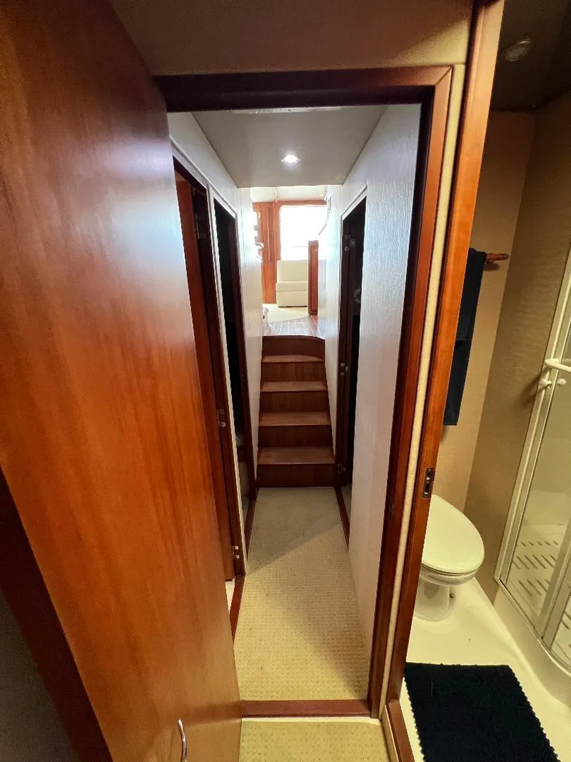 Slide: The Image of 2009 Bertram Convertible yacht interior hallway with wooden doors and bathroom. - 16