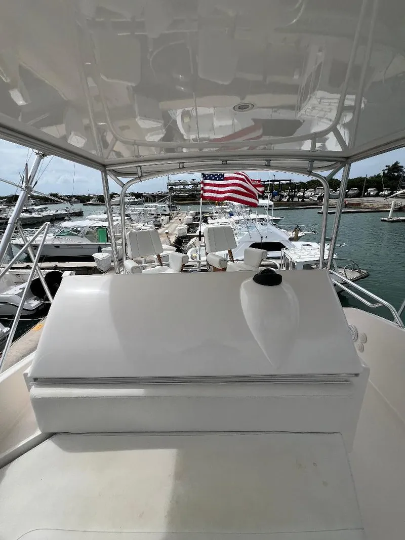 Slide: The Image of 2009 Bertram Convertible yacht docked, featuring a spacious deck and American flag in the background. - 8