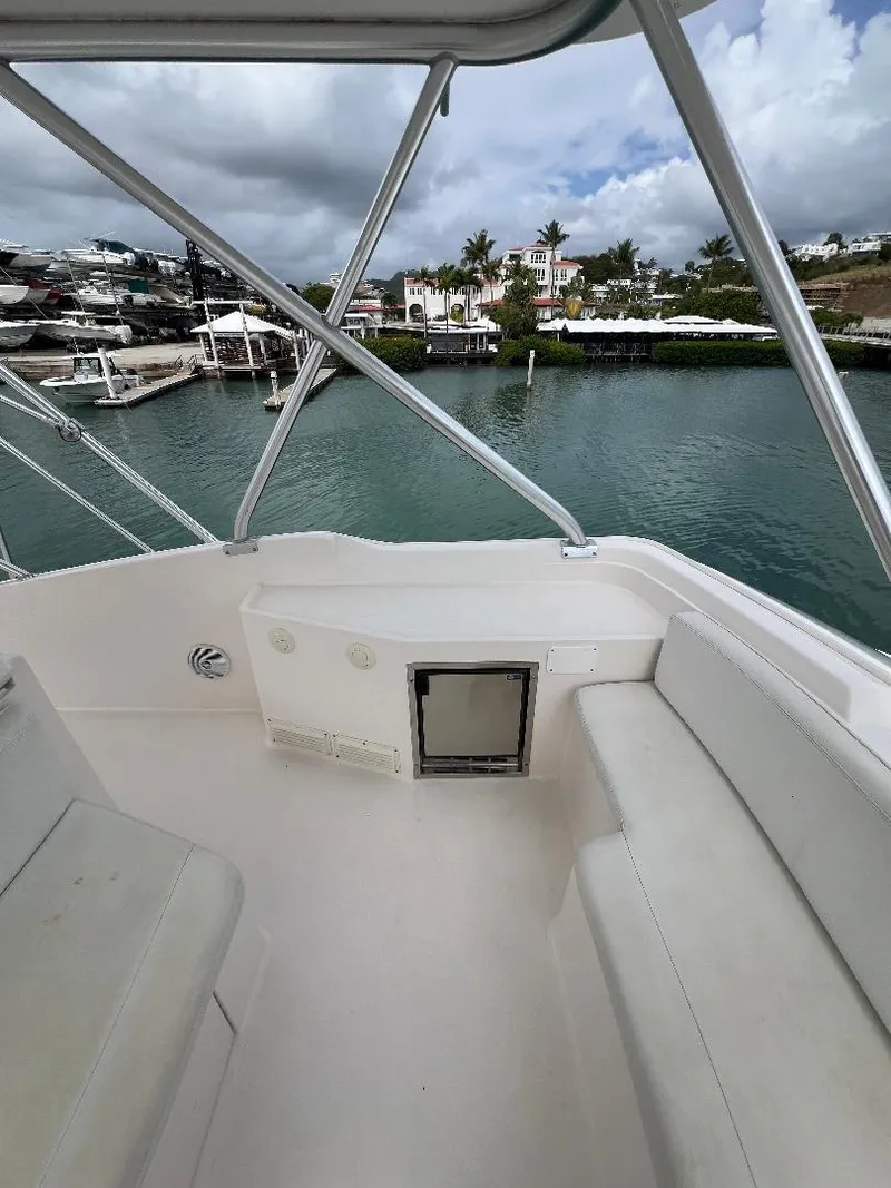 Slide: The Image of 2009 Bertram Convertible boat interior with seating, overlooking a marina and waterfront homes. - 9