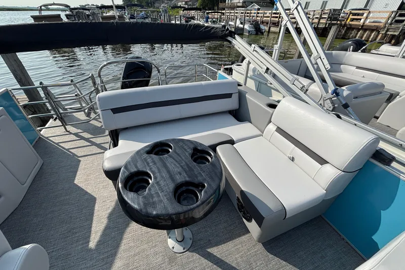Slide: The Image of 2024 Godfrey SW2286SFL pontoon boat interior with seating and cupholder table. - 4