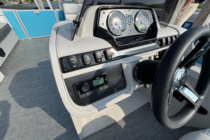 Slide: The Image of 2024 Godfrey SW2286SFL boat dashboard with steering wheel and control panel. - 6