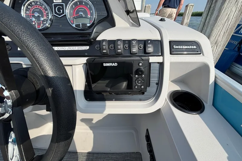 Slide: The Image of 2024 Godfrey SW2286SFL boat dashboard with Simrad display and steering wheel. - 8