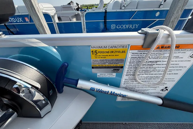 Slide: The Image of 2024 Godfrey SW2286SFL boat capacity label, warning signs, and West Marine equipment. - 9