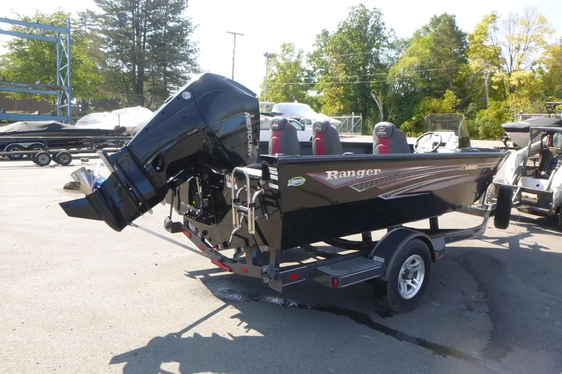Slide: The Image of 2022 Ranger VS1882SC Angler boat on trailer, parked near blue building. - 2