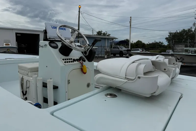 Slide: The Image of 2005 Maverick 18 HPX-V boat interior with steering console and seating, under cloudy sky. - 11