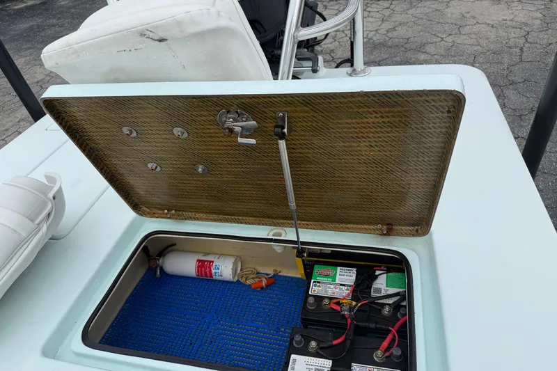 Slide: The Image of Open storage compartment in a 2005 Maverick 18 HPX-V boat, showing batteries and fire extinguisher. - 15