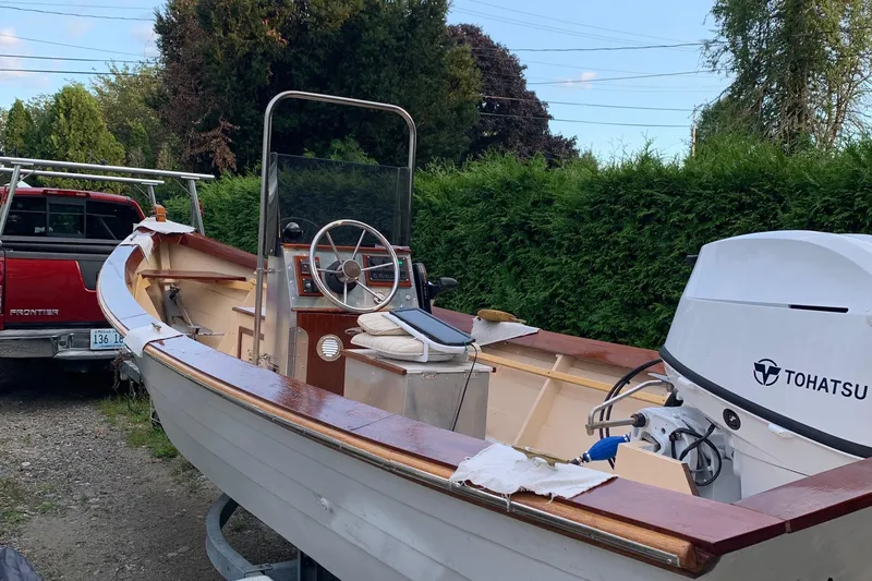 Slide: The Image of 2009 Simmons Sea Skiff 18 with Tohatsu motor, parked beside a red truck. - 4