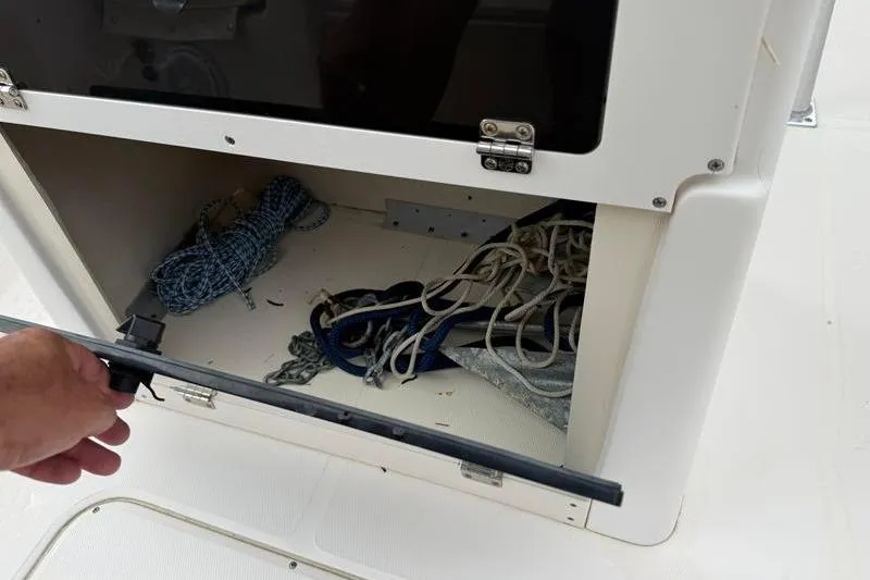 Slide: The Image of Storage compartment on a 2005 Grady-White Escape 209 boat, containing ropes and equipment. - 15