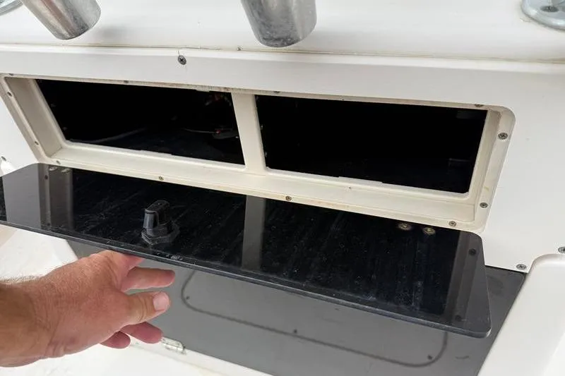 Slide: The Image of 2005 Grady-White Escape 209 boat storage compartment with open hatch and hand. - 16
