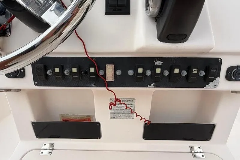 Slide: The Image of Control panel of a 2005 Grady-White Escape 209 boat with steering wheel and switches. - 21