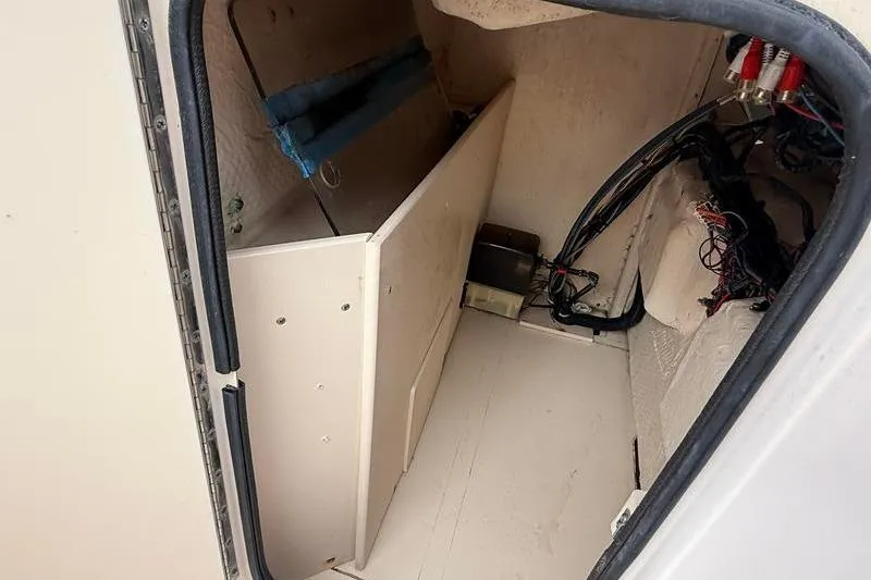 Slide: The Image of 2005 Grady-White Escape 209 storage compartment with wiring and equipment. - 22